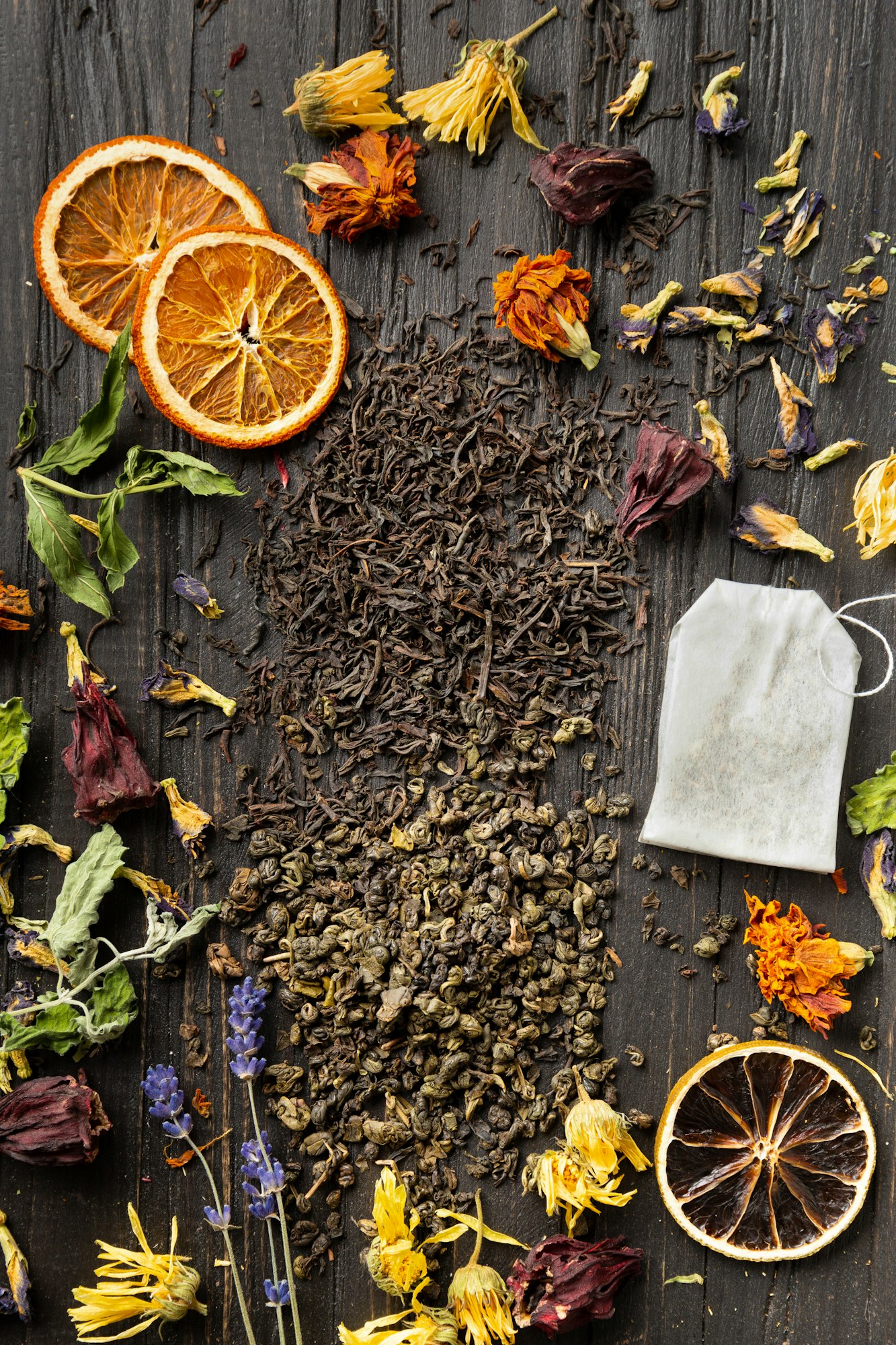Dry green and black tea, tea bag, flower tea on a dark background top view close-up.